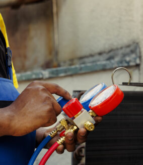 Close up of manometers able to detect hvac system moisture intrusion, refrigerant not circulating and other issues. Trained engineer using barometer set to read air conditioner pressure levels